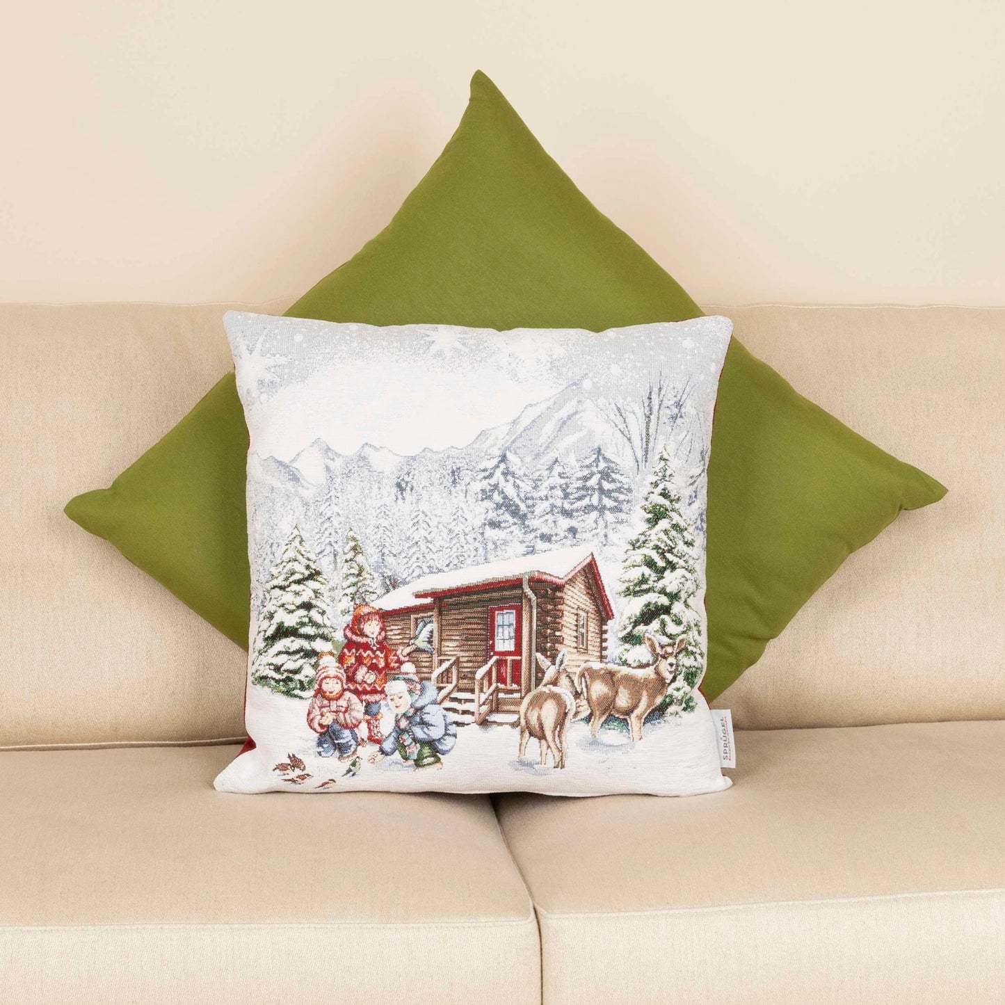 Das Kissen aus Bild 1 und 2 liegt auf einem hellen Sofa, dahinter ist ein weiteres, einfarbiges grünes Kissen zu sehen.