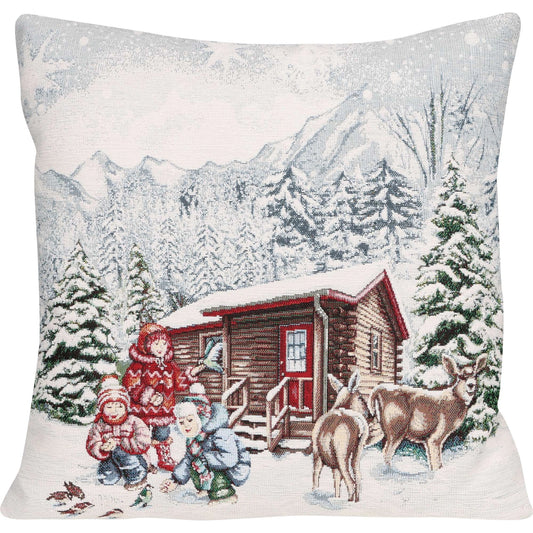 ine quadratische Kissenhülle mit einem sehr detaillierten, winterlichen Motiv. Es zeigt eine verschneite Berglandschaft mit Tannenbäumen und einer rustikalen Holzhütte. Im Vordergrund sind drei Kinder in Winterkleidung zu sehen, die Vögel füttern, und in der Nähe stehen zwei Rehe. 