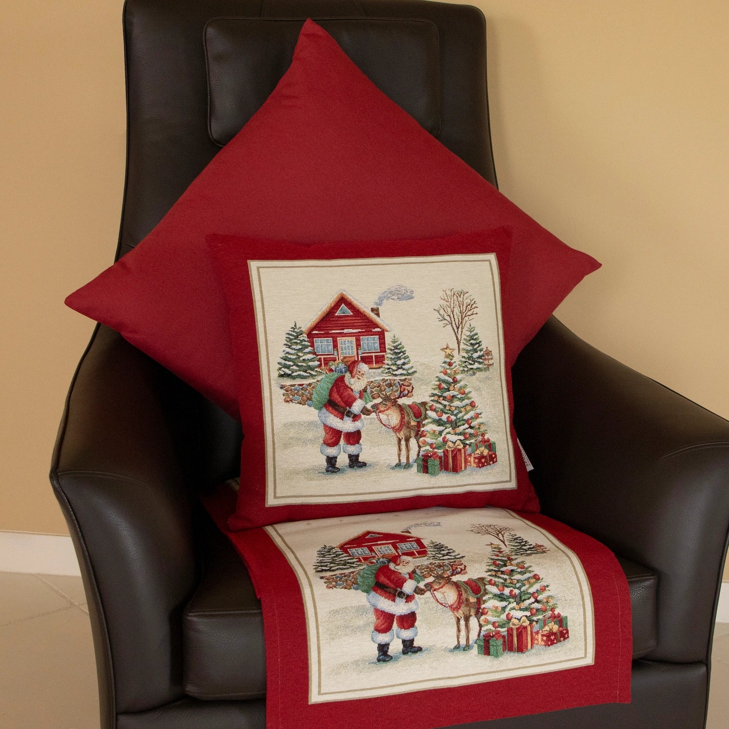 Braunes Ledersofa im Hintergrund dekoriert mit bordeauxrotem Kissen mit Weihnachtsmann und Rentiermotiv