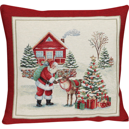 Quadratische Gobelin Kissenhülle 45x45 cm. Weihnachtsmann füttert sein Rentier vor einem roten Haus und einem geschmückten Tannenbaum, mit breiter bordeauxroter Umrandung.