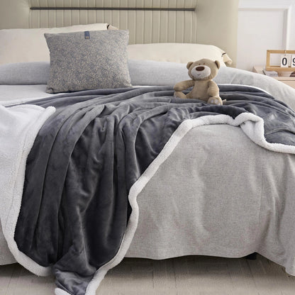 anthrazit Decke auf einem Bett mit einem Teddybär darauf